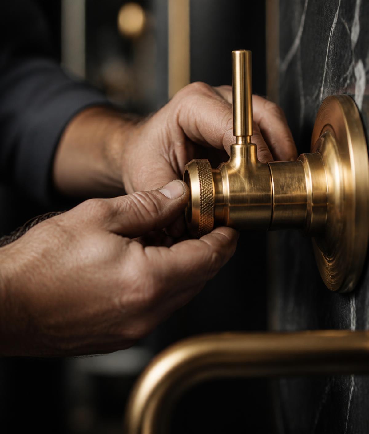 Craftsman fitting a brass fixture in a luxury home
